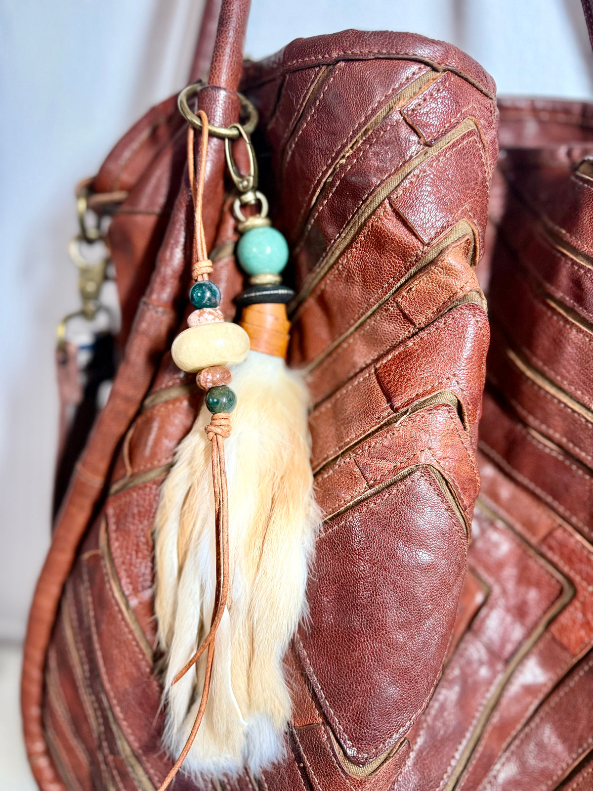 Handcrafted fur bag charm with semiprecious stones and leather detailing by Chasing Sunsets Design. ON BAG